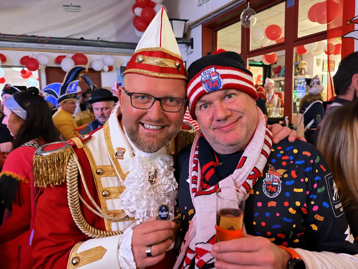 Sascha Frenz in Ehrengarde-Uniform mit einem Karnevalisten im Bonner-SC-Outfit.