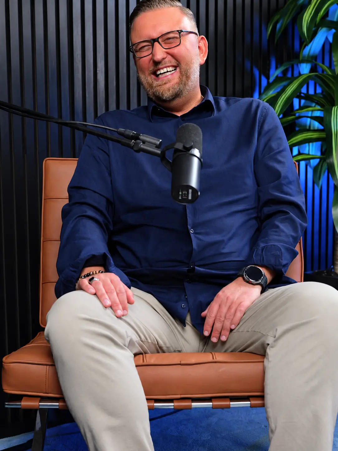 Sascha Frenz lacht offen in einem Podcast-Studio
